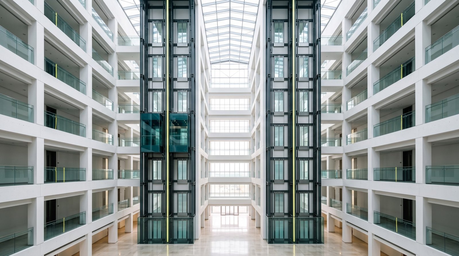 Glass elevators rising through a white atrium